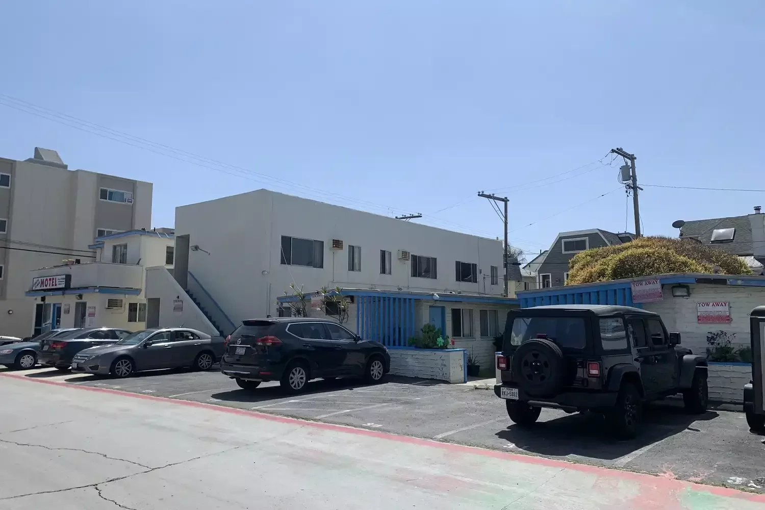 Before: the Santa Clara Motel from its parking lot, with a small office, a blue-railed entry and cars parked out front.