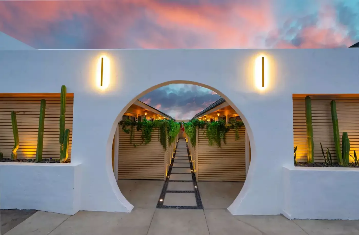 After: the same entry rebuilt as a round moon gate, planted and lit at dusk.