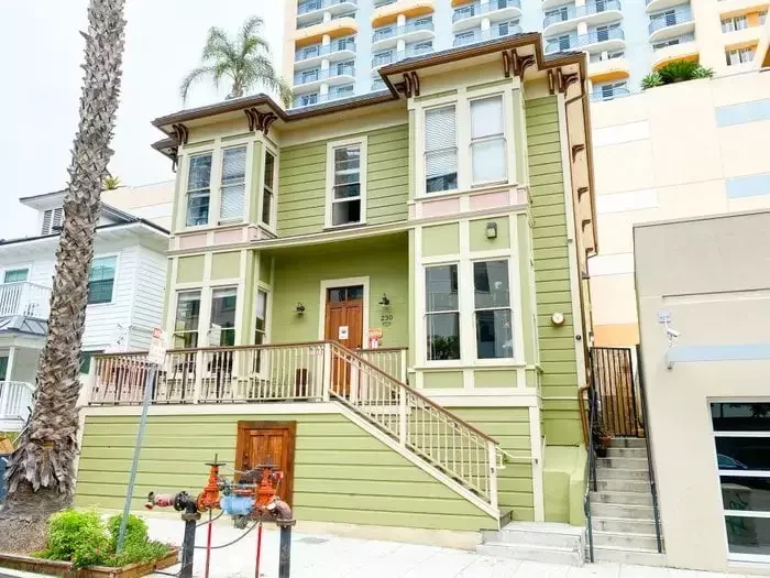 The Little Italy Adventure Hostel: a restored green Victorian with bay windows and a front stair.